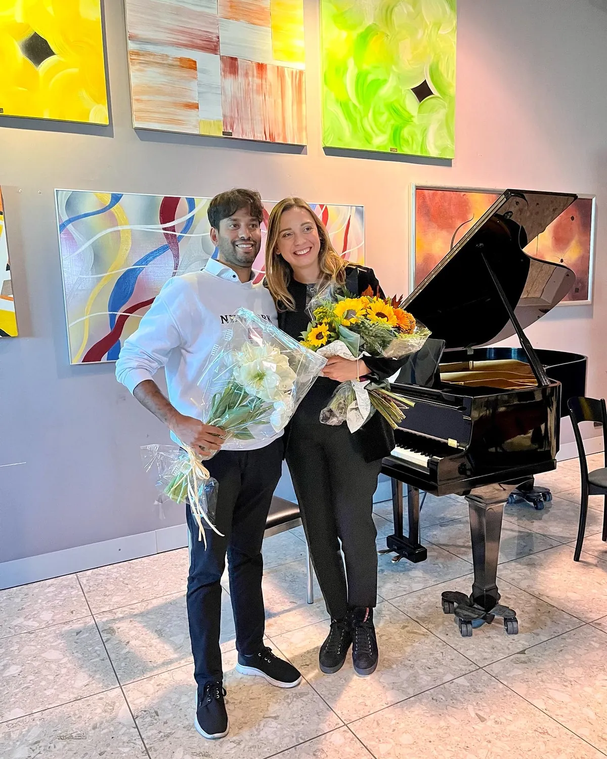 Valentina Dzhegnaradze con un allievo, i mazzi di fiori in mano, dopo un concerto nello studio