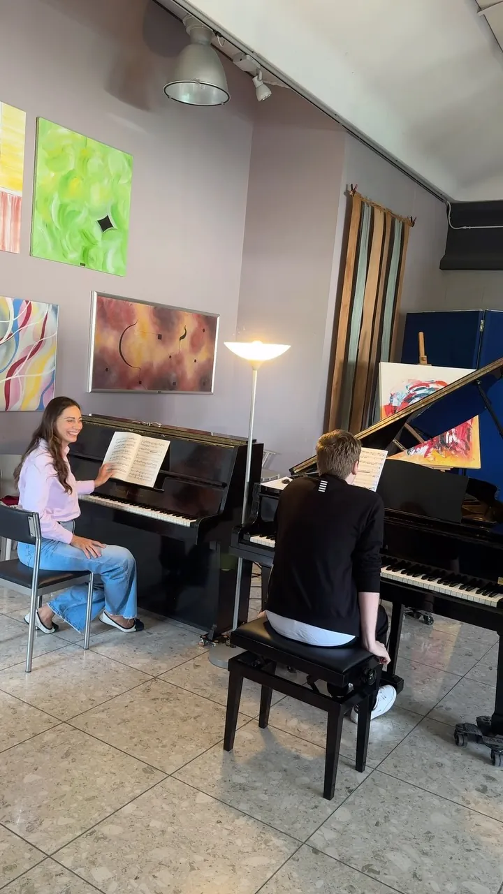 Lo studio di Curno, il primo fotogramma del video: l'allievo e Valentina ai due pianoforti a coda