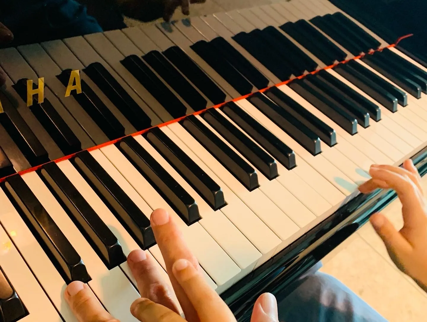 Le mani di un bambino sulla tastiera di un pianoforte Yamaha