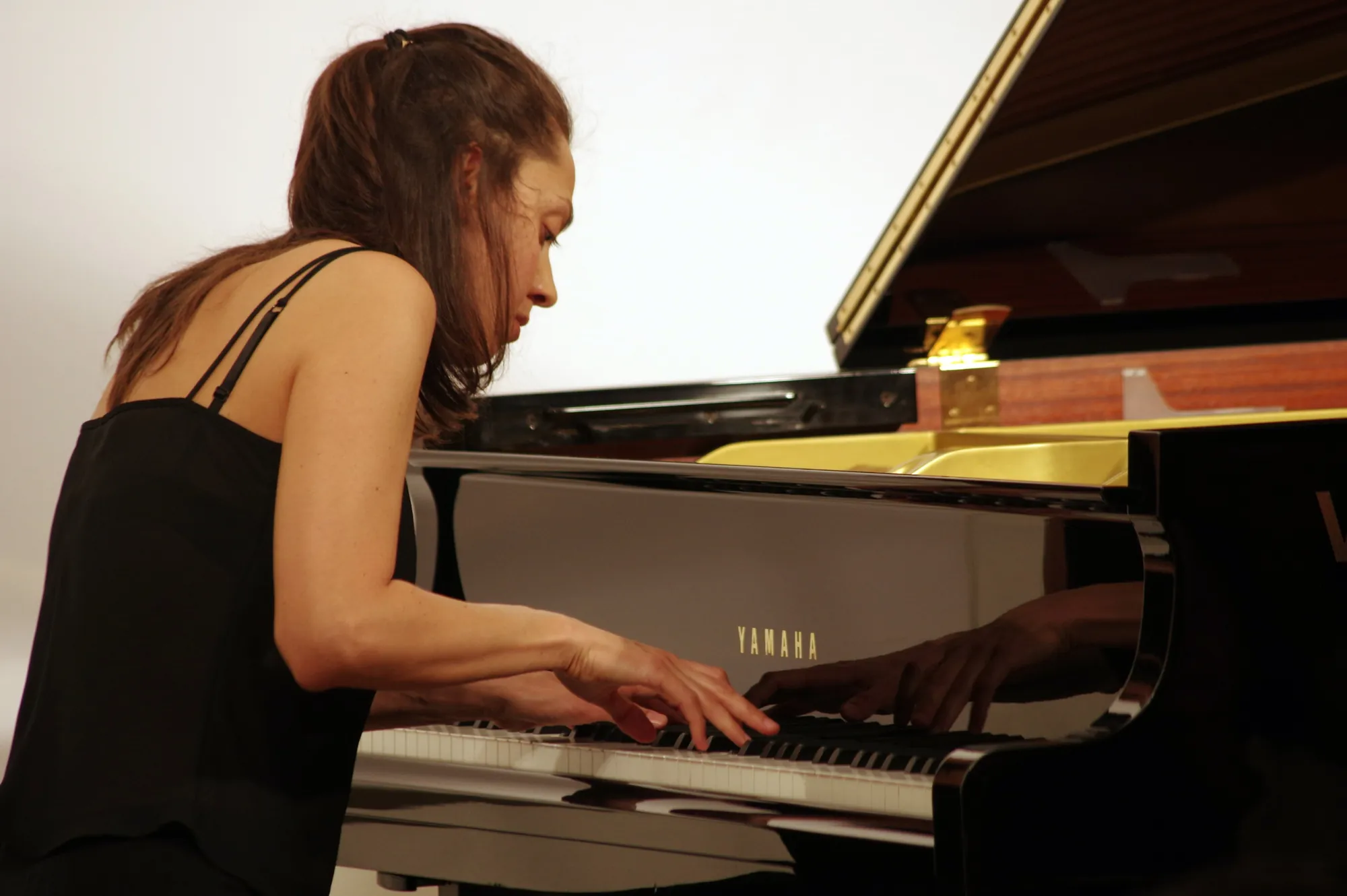 Valentina Dzhegnaradze suona, di profilo, un pianoforte Yamaha